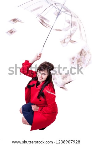 Brunette girl with umbrella in red cloak among falling money bills