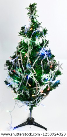 Christmas tree decorated with small lights on the blue-dark background.