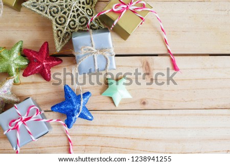 Christmas background with gift boxes and stars on the wooden table with copy space. 