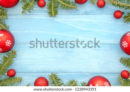 Christmas frame background with red balls decor and fir tree. on light blue background with copy space. Top view.Flat lay xmas new yeard