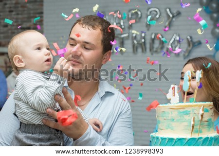 Happy young family celebrating, Blowing out the candles on the cake by the child