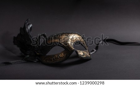 Carnival time. Venetian mask with feathers on black background, copy space