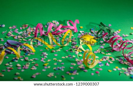 Carnival or birthday party. Confetti and serpentines on bright green background, copy space