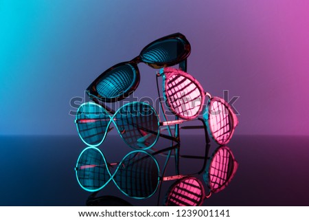 Sunglasses stacked in a pile with vivid color, hot pink and blue. Royalty-Free Stock Photo #1239001141