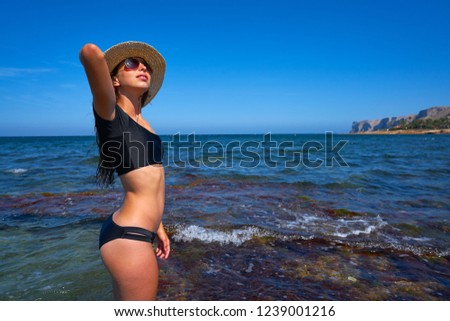 Bikini girl in summer Mediterranean beach having fun with beach hat