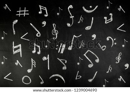 musical notes drawn in white chalk on a blackboard, background image