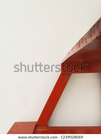 Abstract view of red wooden stairs at white wall at background