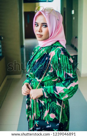 Beautiful young muslim teacher standing near the classroom.