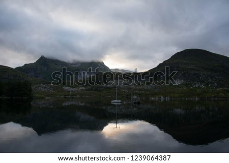 Dramatic mountain and cloud scenery at a lake on Lofoten islands, Norway