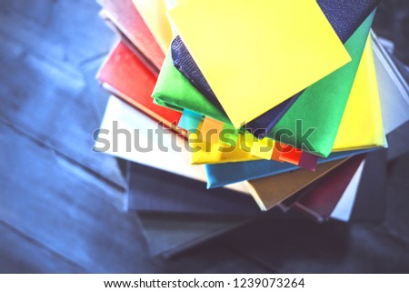 a stack of books stacked in a spiral. on tinted wooden background