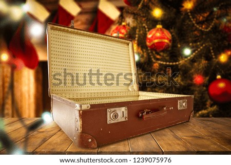 Brown old suitcase and christmas home interior with fireplace and christmas tree. 