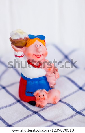 Traditional Ukrainian woman with piglets in her arms on a white background