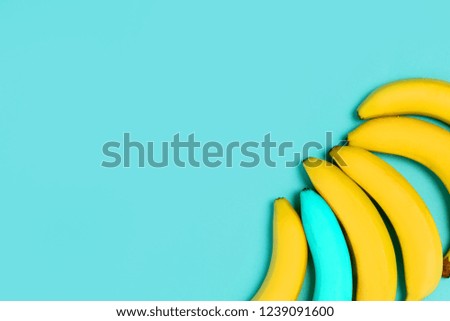 Colorful blue background for text and advertising.Yellow and one blue banana in the corner of the picture. From top view