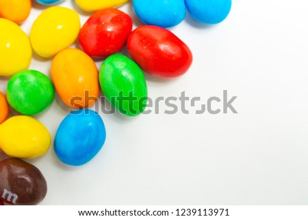Macro photo of multicolored sweet candies in the glaze with peanuts inside in the form of a background, frames and colored inserts of candy