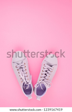 Fashion blog or magazine concept. Pink female sneakers over pastel pink background. Flat lay, top view minimal image for shopping, sales, fashion blog ideas.