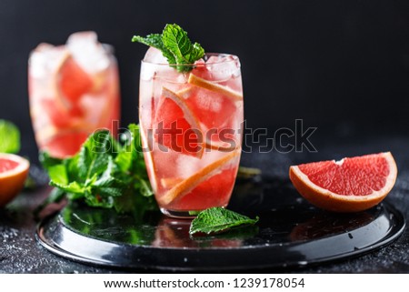 Fresh grapefruit cocktail. Fresh summer cocktail with grapefruit and ice cubes. Glass of grapefruit mojito Royalty-Free Stock Photo #1239178054