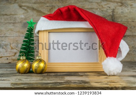 Empty wooden picture frame with santa hat. Christmas decoration beside the frame. With copy space.