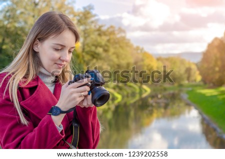 Professional woman photographer taking camera outdoor portraits with prime lens in the photography nature