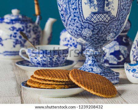 Traditional Dutch stroopwafel with syrup, cookie and tea, Delfts blue decorative crockery set on the table ,close-up, macro photo Royalty-Free Stock Photo #1239208432