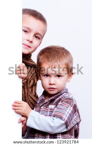 two children behind a white board isolated