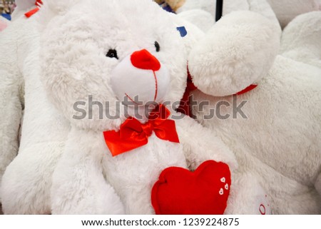 Teddy Bear with red bow holding a Heart                               