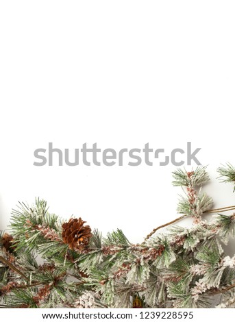 Winter holiday background with fir leaf border. Isolated Christmas Frame with tree branches. Christmas motifs. branches of a Christmas tree with ornaments on the white background
