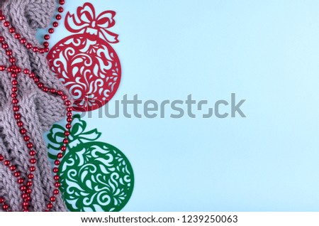 New Year composition with wool scarf., beads, and tree decoration toys Christmas concept background. Flat lay, top view of festive still life