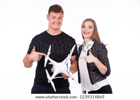 Boy and girl hold flying drone in their hands and smile. Theme selling and buying drone. On a white background.