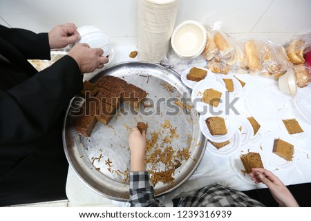 Man cuts and serves traditional Jewish food called "Yerushalmi kugel" which is a noodle souffle cooked with burnt sugar