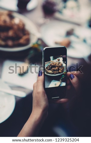 A woman taking photo of food on smartphone, photographing meal with mobile camera