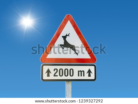 Roadsign deer crossing against a blue sky