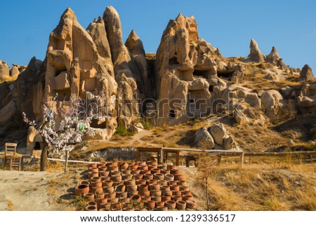 Traditional Turkish clay pots stand on the ground. View of the rocks in the valley near the city of Goreme in Cappadocia, Turkey Anatolia.