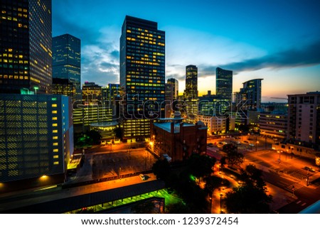 rising urban development in Denver , Colorado , USA at Night Downtown City glowing Nightscape Skyline of the Mile High City Skyscrapers and office buildings rising up into the night sky