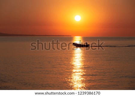 Sunrise on sea with fisherman is sailing throught sun path