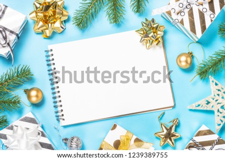 Christmas flatlay background. Silver and gold christmas decorations and present box on blue background with space for your text.