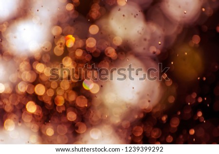 Blurred natural background with soft focus golden bokeh lights. Defocused and cross processed background, perfect for creative designs.