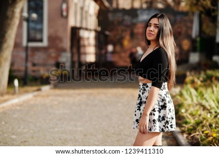 Pretty latino model girl from Ecuador wear on black tops and skirt posed at street. 