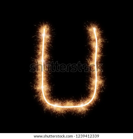 Letter U of alphabet written by squib sparks on a black background.