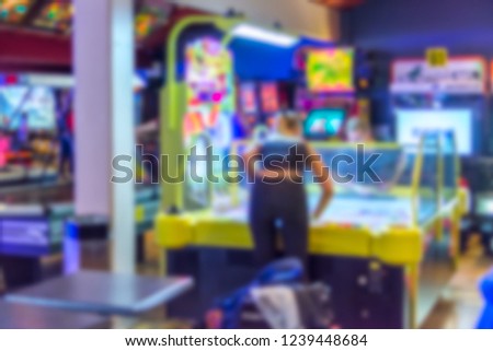 Abstract and Blurred People in an Arcade Playing Games for Background Use