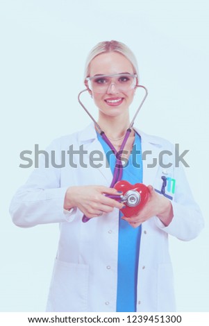 Young woman doctor holding a red heart, isolated on white background. Woman doctor