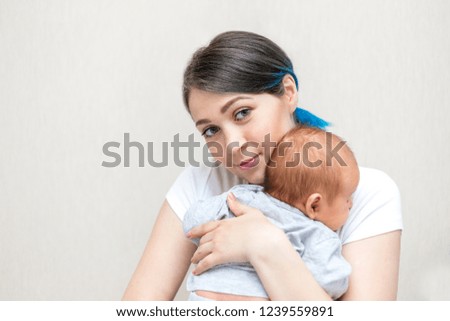 Young mother holding her newborn child. Mom nursing baby.