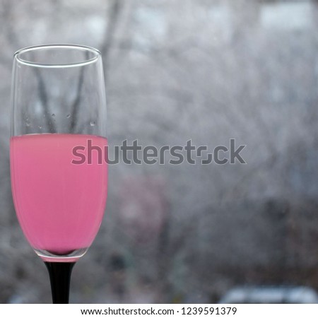 Glass on winter background. Snowflakes on the window. New year and Christmas. Cool atmosphere.
