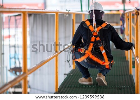 Construction worker wearing safety harness and safety line working on construction
 Royalty-Free Stock Photo #1239599536