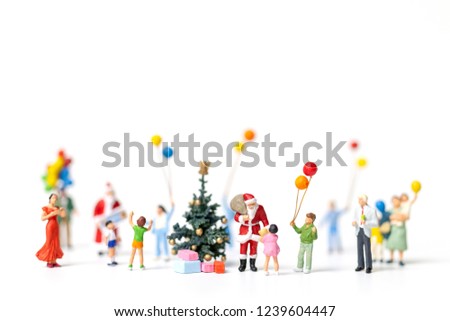 Miniature people : Santa Claus holding gift for happy family , Christmas and Happy New Year concept.