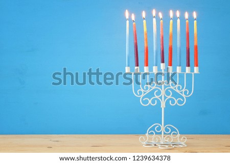 image of jewish holiday Hanukkah background with menorah (traditional candelabra) and colorful candles