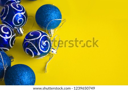 Christmas blue baubles for decoration  isolated on the yellow background