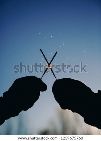 two burning sparklers against the sky
