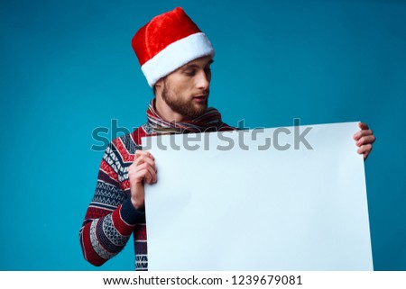 man in christmas hat holding a sheet of paper             