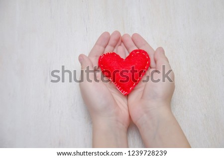 small heart sewn in children's hands selective focus