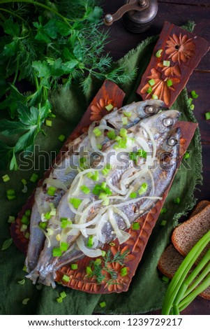 Stewed fish Ryapushka with onions, top view, selective focus